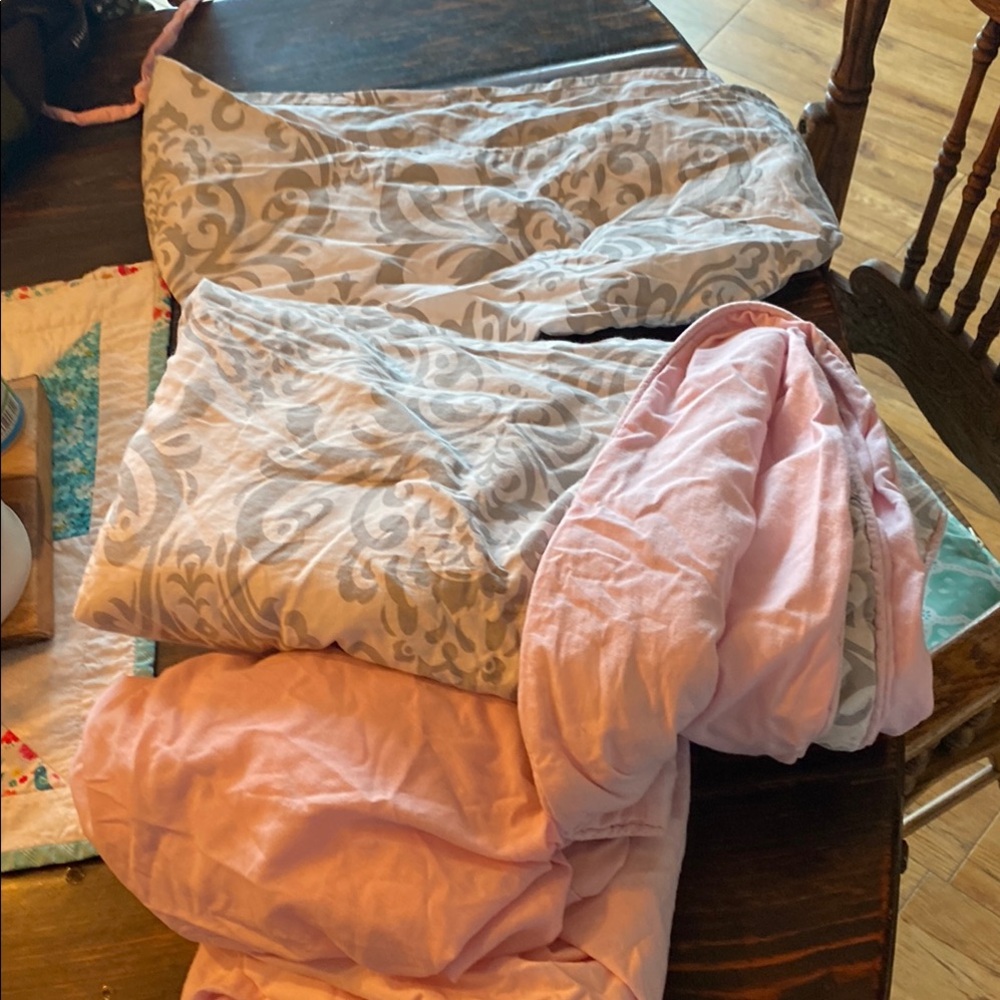 Pink and Gray Patterned crib blanket, 2 pink sheets, and a matching pet net.